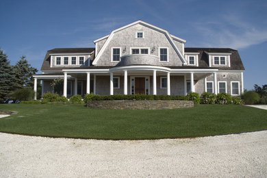 Cette photo montre une grande façade de maison grise chic à un étage.