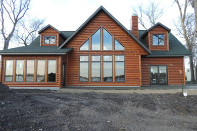 Imagen de fachada de casa marrón rústica de tamaño medio de dos plantas con revestimiento de madera, tejado a dos aguas y tejado de teja de madera