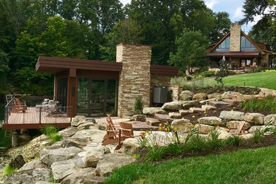 Small trendy beige one-story stone exterior home photo in Other with a green roof