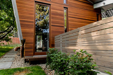 Example of a mid-sized trendy orange one-story wood exterior home design in Denver with a shed roof and a metal roof