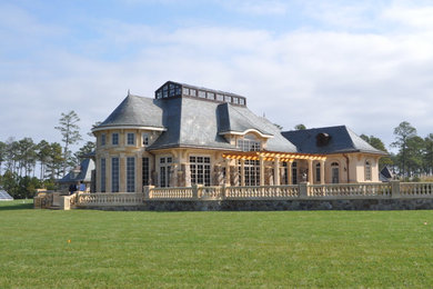 Imagen de fachada de casa beige mediterránea extra grande a niveles con revestimientos combinados, tejado a cuatro aguas y tejado de teja de madera