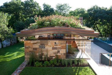 1960s one-story stone exterior home photo in Austin with a gambrel roof and a metal roof