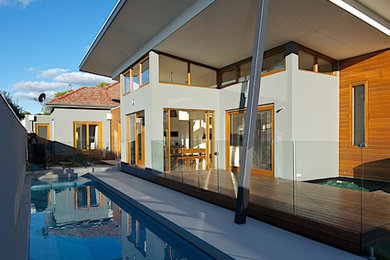 Inspiration pour une façade de maison grise minimaliste en béton de taille moyenne et de plain-pied avec un toit en appentis.