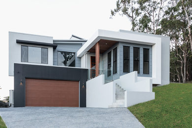 Ejemplo de fachada de casa minimalista de tamaño medio a niveles con tejado de metal