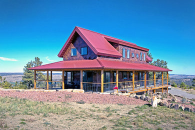 Ejemplo de fachada de casa roja actual de tamaño medio de dos plantas con revestimiento de metal y tejado de metal