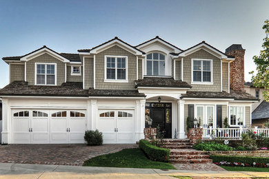 Traditional beige two-story wood house exterior idea in Orange County with a shingle roof
