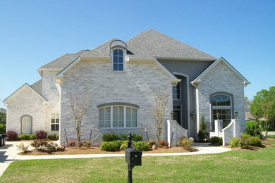 Immagine della facciata di una casa bianca classica a due piani con rivestimento in mattoni