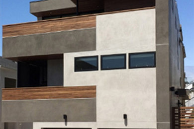 Diseño de fachada beige moderna de tres plantas con revestimiento de estuco