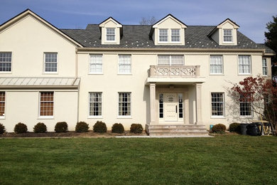 Example of a huge classic beige three-story stucco gable roof design in New York