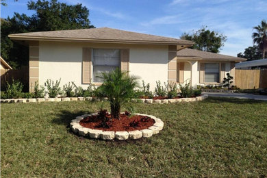 Medium sized and beige classic bungalow house exterior in Orlando with mixed cladding and a hip roof.