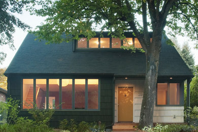 Modelo de fachada verde tradicional de tamaño medio de dos plantas con revestimiento de madera y tejado a dos aguas