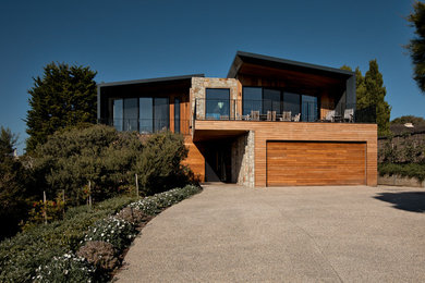 Свежая идея для дизайна: большой, двухэтажный, деревянный, коричневый частный загородный дом с плоской крышей и металлической крышей - отличное фото интерьера