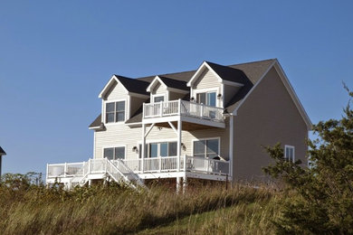 Example of a large beach style beige three-story vinyl exterior home design in Bridgeport
