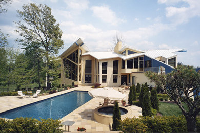 Ejemplo de fachada de casa beige contemporánea de tres plantas con revestimiento de estuco y tejado de metal