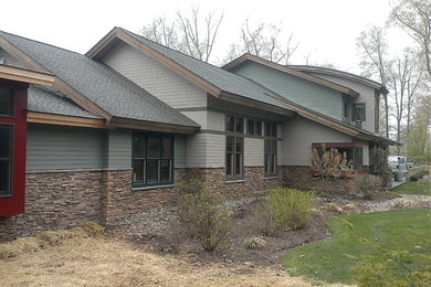 Foto de fachada gris tradicional grande de dos plantas con revestimientos combinados y tejado a dos aguas