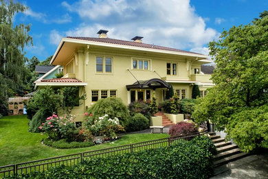 Example of a huge tuscan yellow three-story stucco exterior home design in Portland with a tile roof