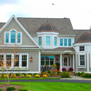 Large elegant beige two-story wood exterior home photo in Detroit with a mixed material roof