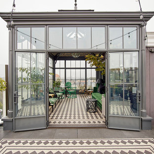 Foto de fachada gris, bohemia, de tres plantas, con revestimiento de vidrio y tejado de metal