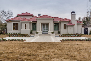 Example of a large transitional gray two-story stucco house exterior design in Dallas with a tile roof