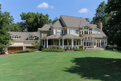 Transitional beige two-story stone gable roof photo in Raleigh