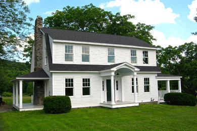 Ornate white two-story concrete fiberboard house exterior photo in New York with a gambrel roof
