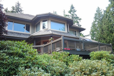 Example of an arts and crafts green three-story wood exterior home design in Seattle