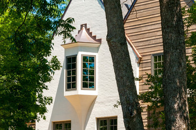 Imagen de fachada de casa blanca clásica de tamaño medio de tres plantas con revestimientos combinados, tejado a cuatro aguas y tejado de metal