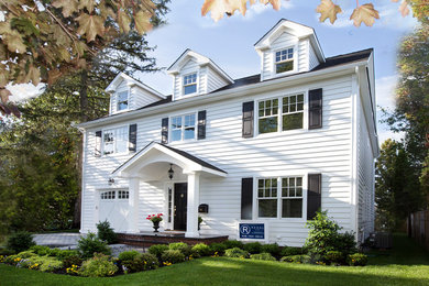 Cette image montre une façade de maison blanche traditionnelle de taille moyenne et à deux étages et plus avec un revêtement en vinyle, un toit à deux pans et un toit en shingle.