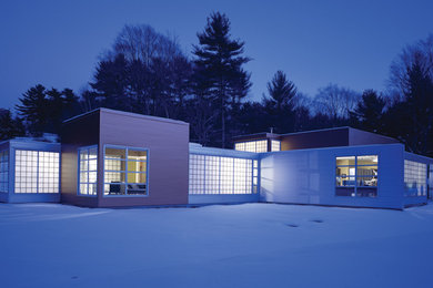Imagen de fachada blanca minimalista grande de una planta con revestimiento de metal y tejado plano