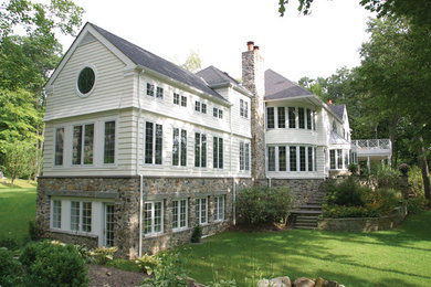 Modelo de fachada de casa multicolor clásica grande de tres plantas con revestimientos combinados, tejado a cuatro aguas y tejado de teja de madera