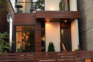 This is an example of a medium sized and beige modern two floor house exterior in Chicago with mixed cladding and a flat roof.
