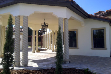 Diseño de fachada de casa blanca mediterránea grande de una planta con revestimiento de estuco, tejado a cuatro aguas y tejado de teja de barro