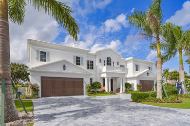Large coastal white two-story stucco house exterior idea in Miami with a hip roof