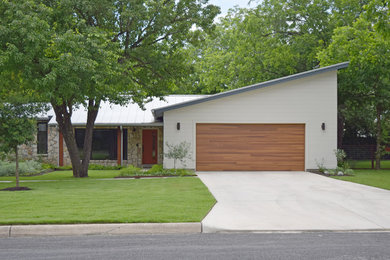 Example of a mid-sized trendy white one-story mixed siding house exterior design in Austin with a shed roof and a metal roof