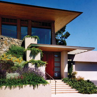 Idee per la facciata di una casa moderna a due piani con rivestimento in stucco