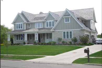 Modelo de fachada de casa gris de estilo americano grande de dos plantas con revestimientos combinados, tejado a dos aguas y tejado de teja de madera
