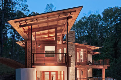 Expansive and brown contemporary house exterior in Atlanta with three floors, mixed cladding and a lean-to roof.