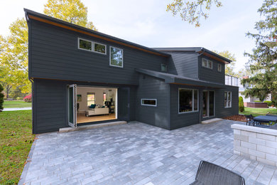 Imagen de fachada de casa gris actual de tamaño medio de dos plantas con revestimiento de vinilo, tejado a dos aguas y tejado de metal