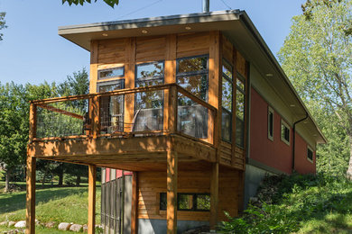 Example of a small trendy red two-story mixed siding house exterior design in Milwaukee with a shed roof