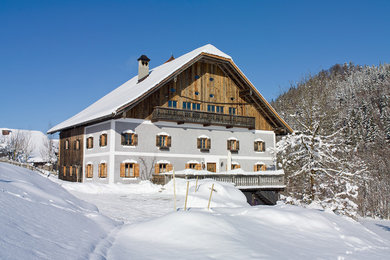 Foto della casa con tetto a falda unica grande marrone rustico a tre piani con rivestimento in legno