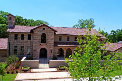Example of a large tuscan brown two-story stone exterior home design in Phoenix with a hip roof