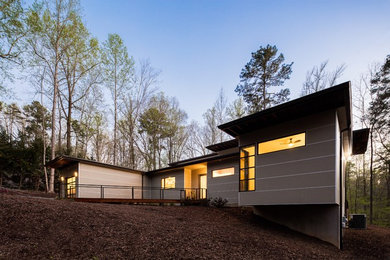 Example of a small minimalist beige one-story concrete fiberboard flat roof design in Raleigh