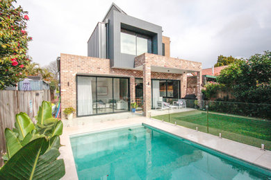 Diseño de fachada de casa gris y gris moderna de dos plantas con revestimiento de ladrillo y tejado de metal