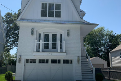 Modelo de fachada de casa blanca campestre de tamaño medio de tres plantas con revestimiento de madera, tejado a dos aguas y tejado de teja de madera