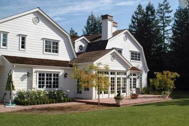 Example of a large classic white two-story wood exterior home design in San Francisco with a gambrel roof