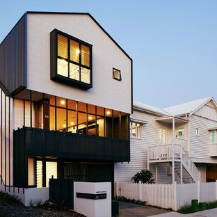 Photo of a contemporary three-storey white house exterior in Brisbane with mixed siding and a gable roof.