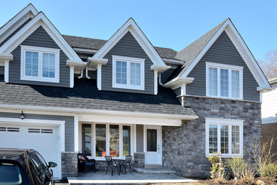 Example of a large transitional gray two-story wood gable roof design in Toronto