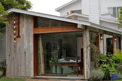 This is an example of a medium sized and brown contemporary bungalow house exterior in Los Angeles with wood cladding and a pitched roof.