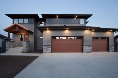 Aménagement d'une façade de maison grise contemporaine de taille moyenne et à un étage avec un revêtement mixte et un toit à quatre pans.