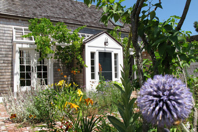 Example of a mid-sized classic brown one-story wood exterior home design in Boston with a shingle roof